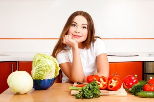 Niña y verduras sobre la mesa